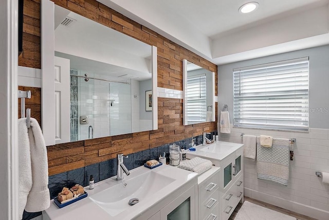 bathroom featuring vanity, tile walls, and a shower with shower door