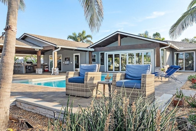 rear view of property featuring a patio and exterior kitchen