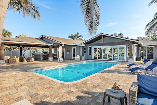 view of swimming pool featuring exterior kitchen and a patio