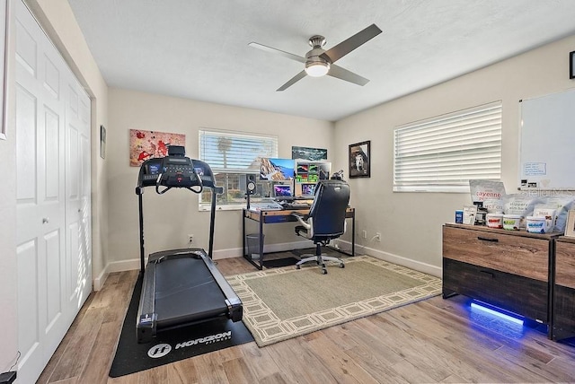 workout area with ceiling fan and light wood-type flooring