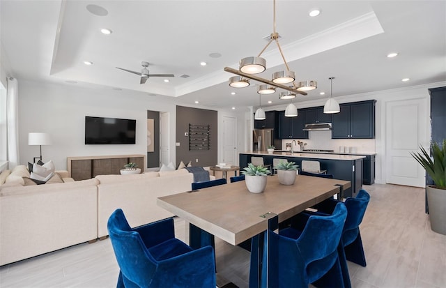 dining space featuring crown molding, a tray ceiling, and ceiling fan