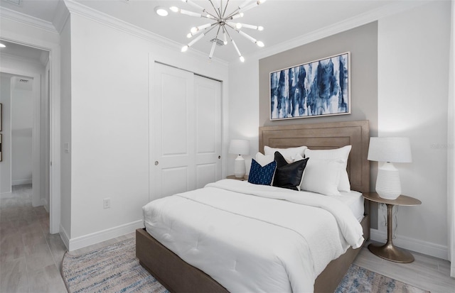 bedroom featuring ornamental molding, light hardwood / wood-style flooring, a notable chandelier, and a closet