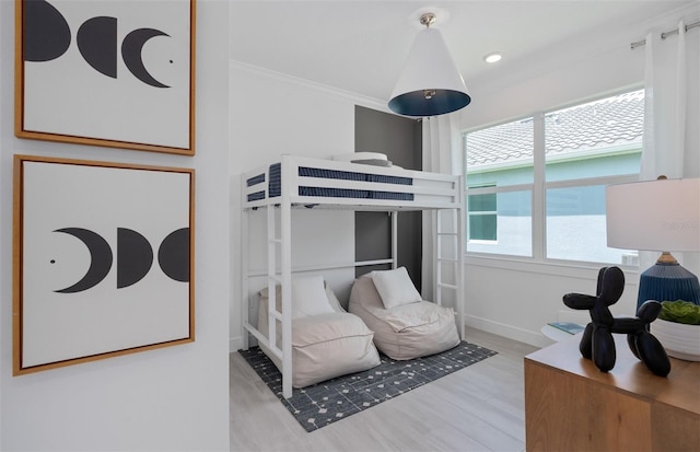 bedroom featuring ornamental molding and light wood-type flooring