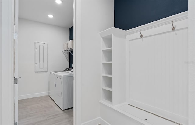 laundry room with light hardwood / wood-style flooring, electric panel, and washer and dryer