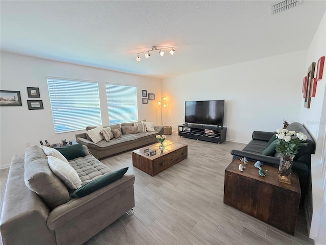 living room with light hardwood / wood-style flooring and a textured ceiling