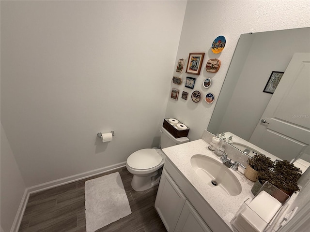 bathroom with vanity, wood-type flooring, and toilet