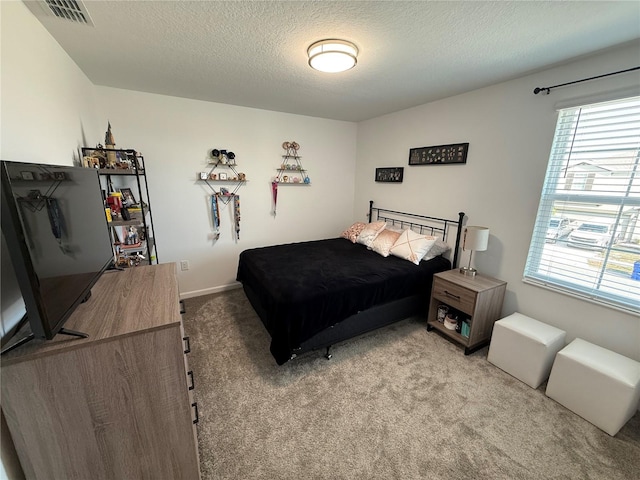 bedroom with light carpet and a textured ceiling