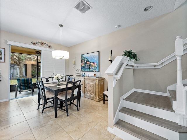 tiled dining space with a textured ceiling