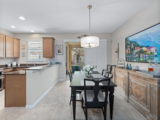 dining area featuring sink and light tile patterned floors