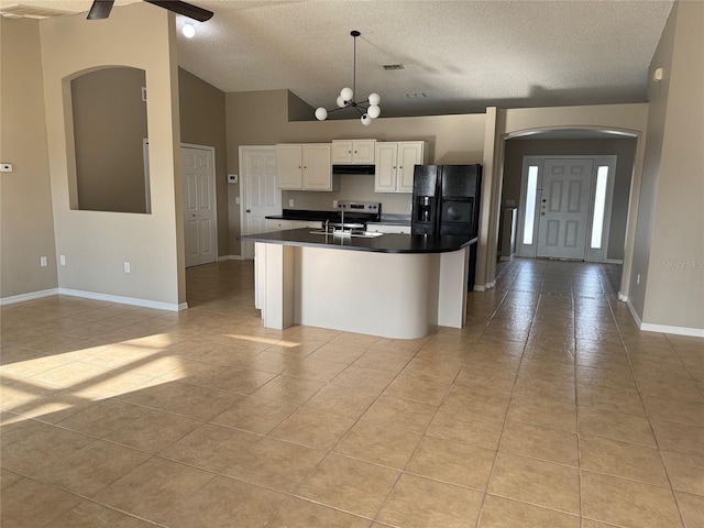 kitchen with sink, black refrigerator with ice dispenser, a center island with sink, pendant lighting, and white cabinets