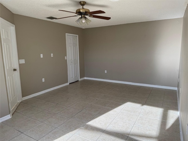 tiled empty room with a textured ceiling and ceiling fan