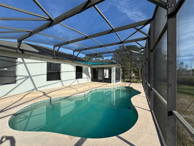 view of pool with a patio area and glass enclosure