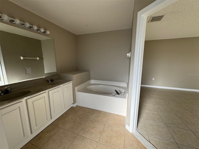 bathroom with vanity, tiled bath, tile patterned flooring, and a textured ceiling