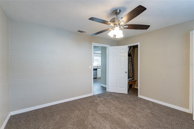 empty room with ceiling fan, sink, and carpet