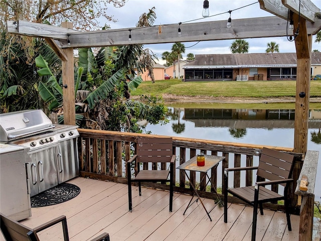 wooden terrace featuring a yard and a water view