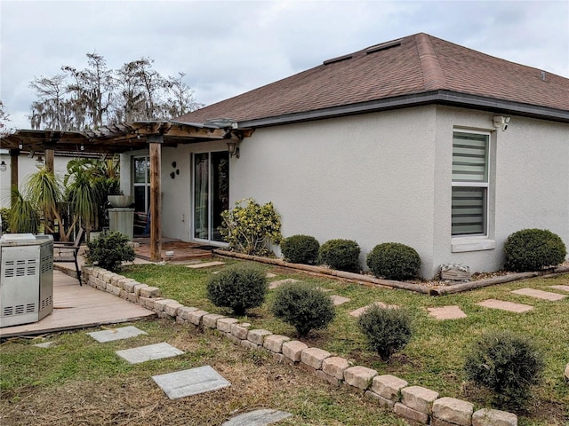 view of side of home with a pergola and a lawn