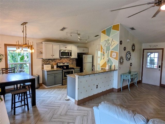 kitchen featuring white cabinetry, hanging light fixtures, stainless steel appliances, tasteful backsplash, and kitchen peninsula