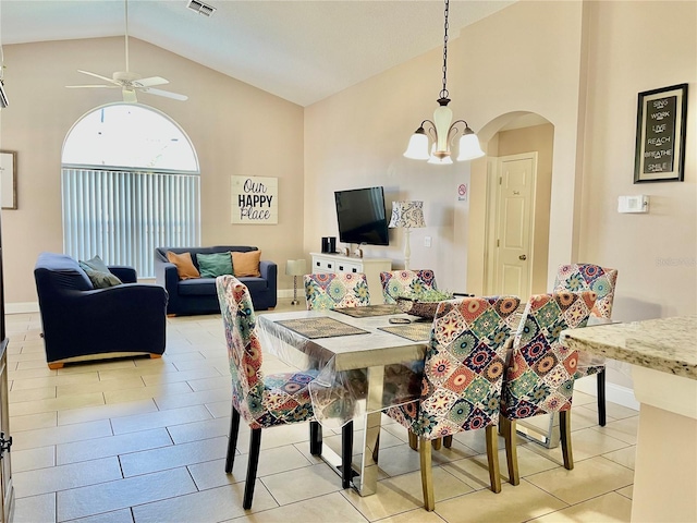 dining space with ceiling fan with notable chandelier and high vaulted ceiling