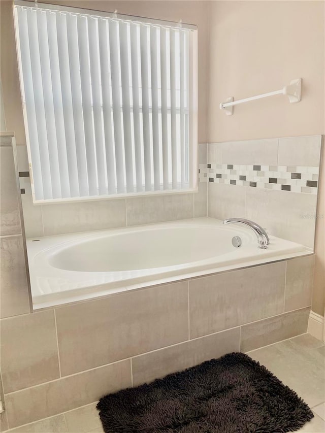 bathroom with tiled bath and tile patterned floors