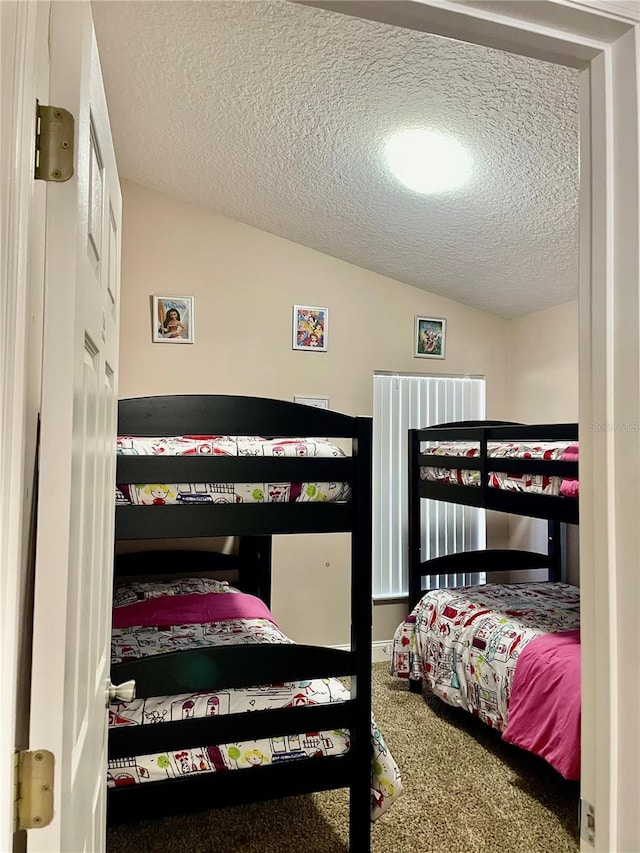 carpeted bedroom featuring vaulted ceiling and a textured ceiling