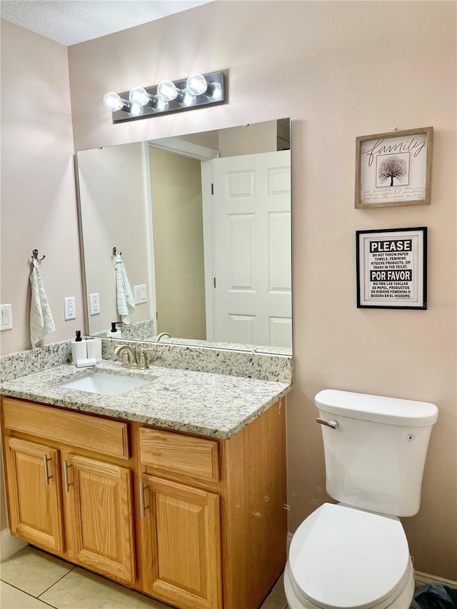 bathroom with vanity, toilet, and tile patterned flooring