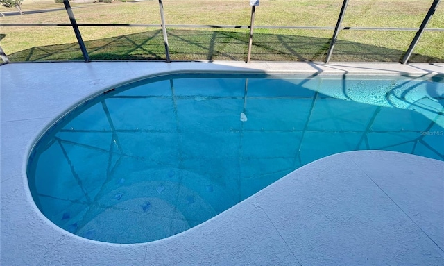 view of pool with glass enclosure