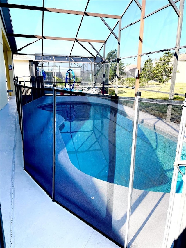 view of pool with glass enclosure