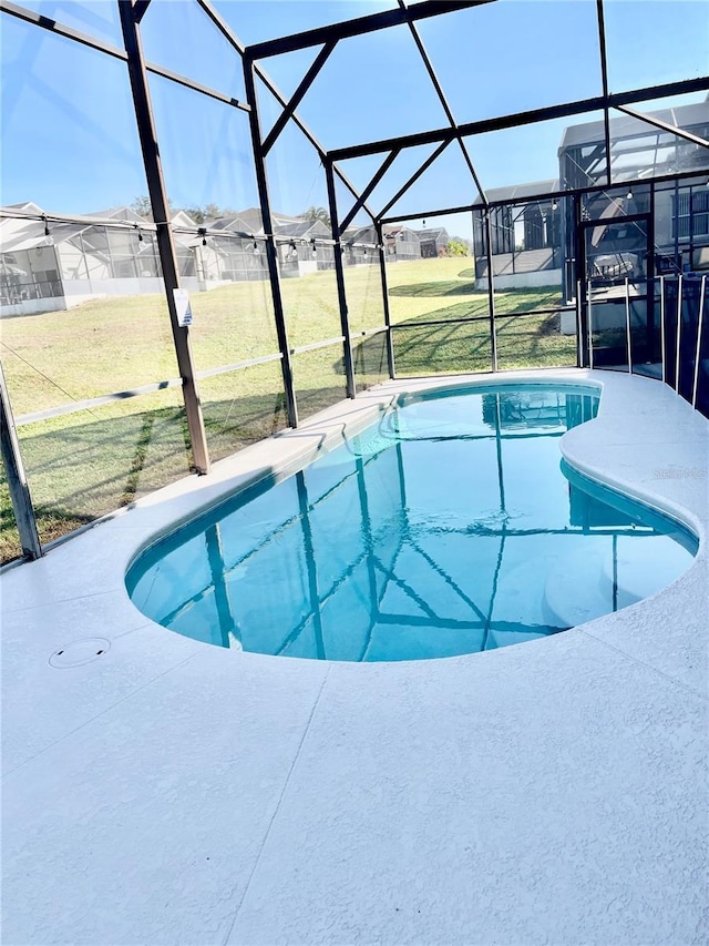 view of pool featuring a lanai, a lawn, and a patio