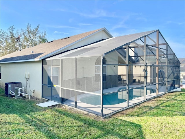 view of side of property with a lanai, a yard, central AC unit, and a patio area