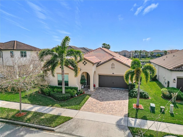 mediterranean / spanish-style house featuring a garage and a front lawn