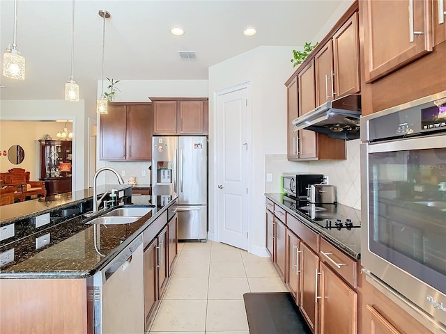 kitchen with pendant lighting, sink, a kitchen island with sink, light tile patterned floors, and stainless steel appliances