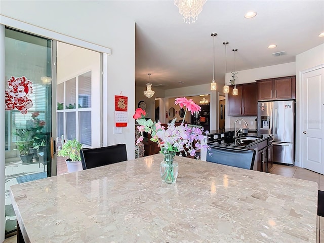 dining room with an inviting chandelier, sink, and light tile patterned floors