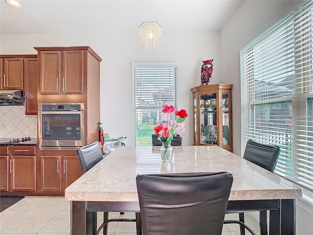 tiled dining room featuring a chandelier