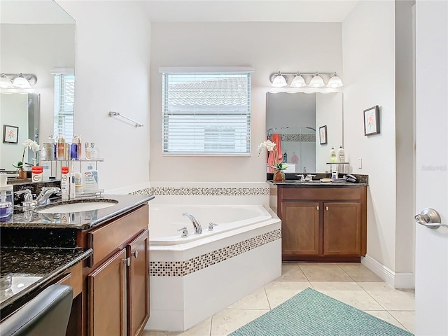 bathroom featuring tiled tub, vanity, and tile patterned floors