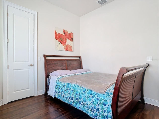 bedroom with dark hardwood / wood-style flooring