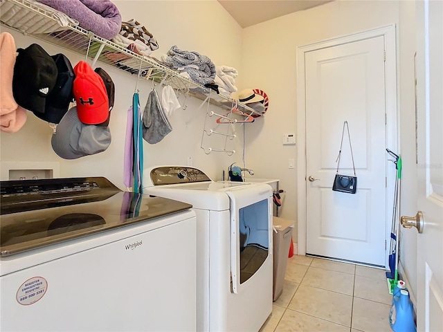 clothes washing area featuring washer and clothes dryer and light tile patterned flooring