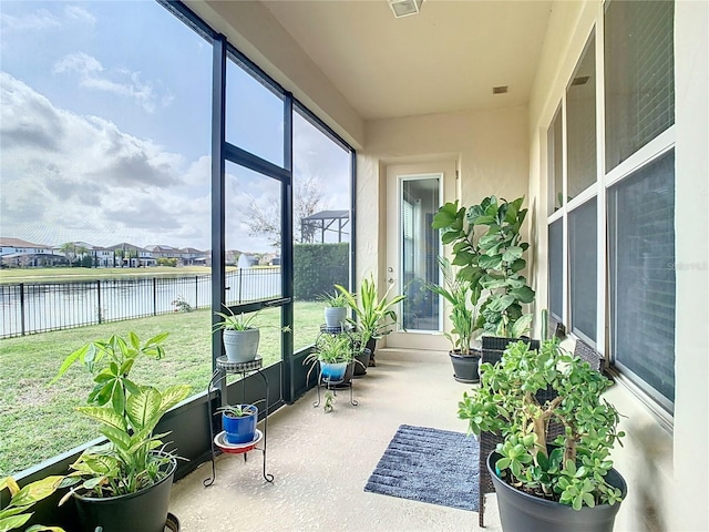 sunroom featuring a water view