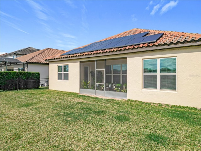 rear view of house featuring a sunroom and a yard