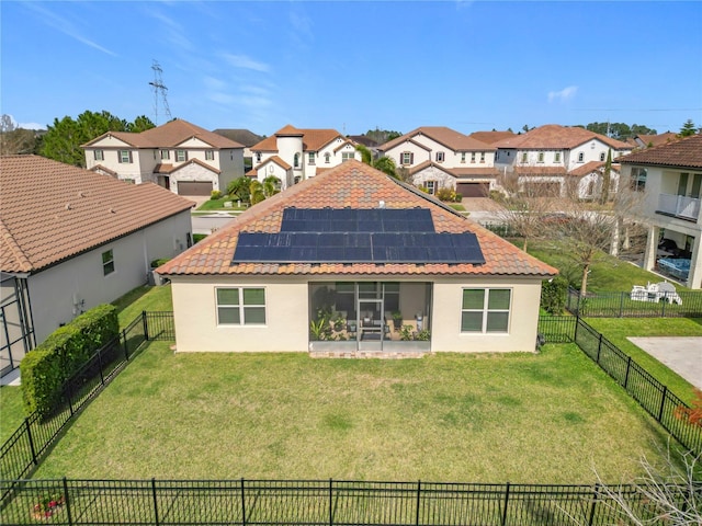 rear view of house featuring a yard and solar panels