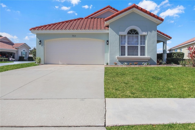 mediterranean / spanish-style house featuring a garage and a front lawn