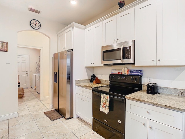 kitchen with light stone counters, stainless steel appliances, light tile patterned floors, and white cabinets