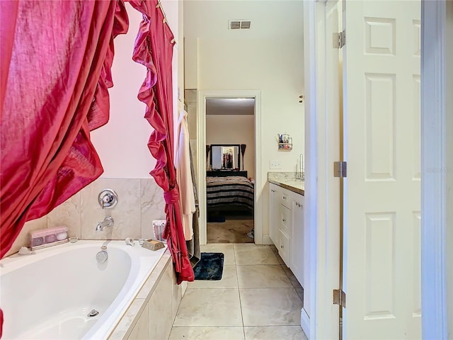 bathroom with vanity, a relaxing tiled tub, and tile patterned floors