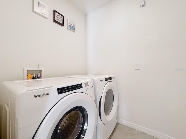 clothes washing area with light tile patterned floors and washing machine and clothes dryer