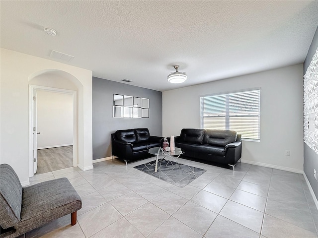 tiled living room featuring a textured ceiling