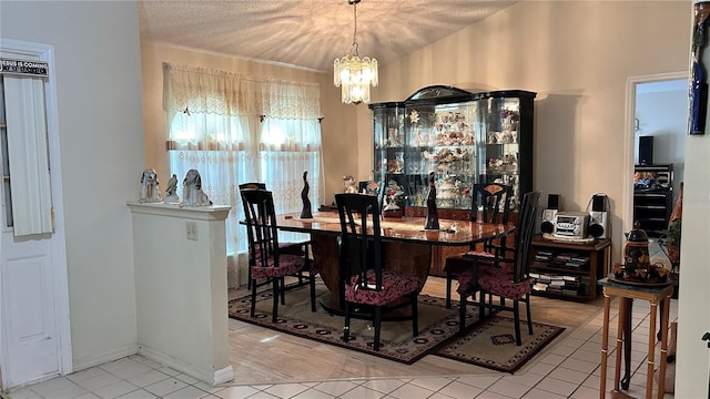 dining room featuring a chandelier, a textured ceiling, and light tile patterned floors