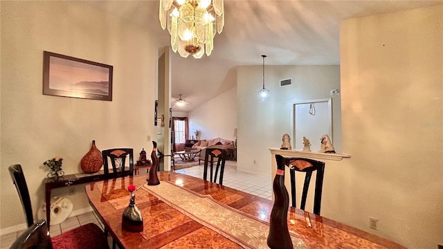 tiled dining area with vaulted ceiling and a chandelier