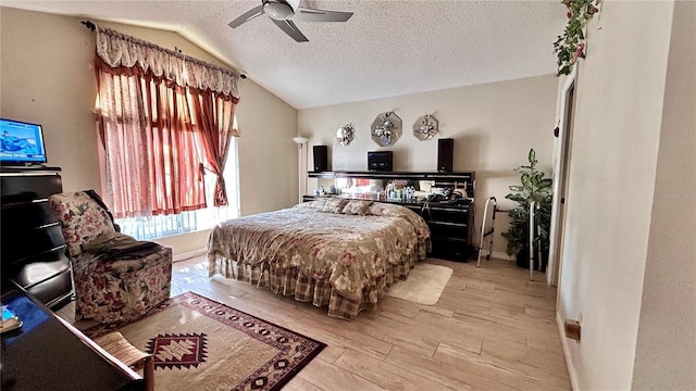 bedroom featuring vaulted ceiling, ceiling fan, light hardwood / wood-style floors, and a textured ceiling