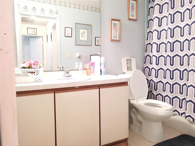 bathroom featuring vanity, tile patterned flooring, toilet, and walk in shower