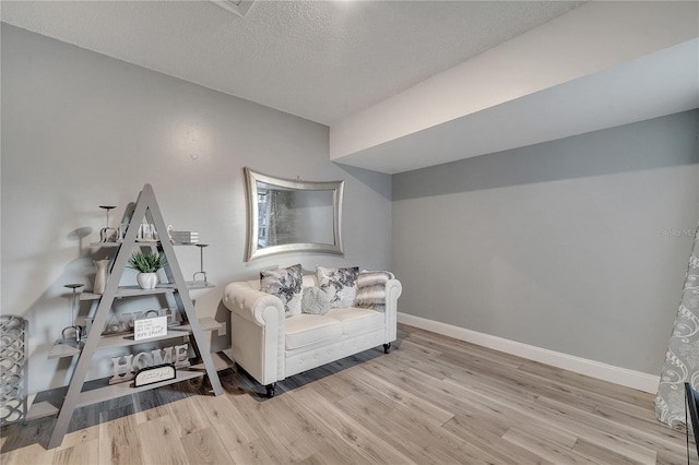 interior space with a textured ceiling and light hardwood / wood-style flooring