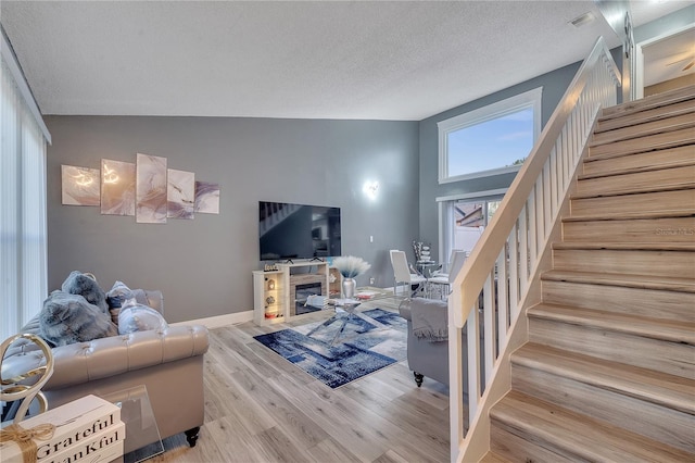 living room with light hardwood / wood-style flooring and a textured ceiling